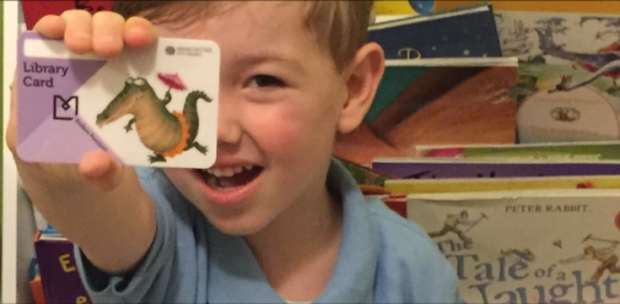 Child with his library card. Photo credit: Manchester libraries